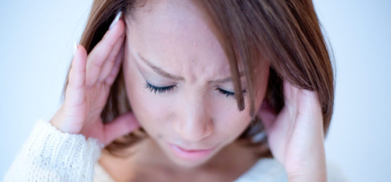 片頭痛の症状で苦しむ女性